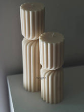 Load image into Gallery viewer, Three ribbed candles stacked on a reflective surface with a gray background