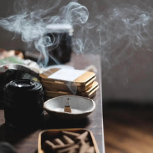 Load image into Gallery viewer, Incense burning with smoke rising from a small bowl on a wooden surface.