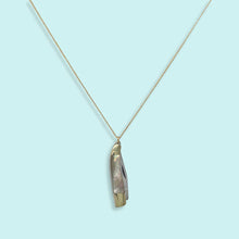 Load image into Gallery viewer, Necklace with a unique pendant on a light blue background