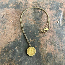 Load image into Gallery viewer, Gold necklace with a coin pendant on a textured surface