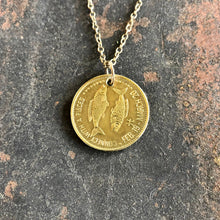 Load image into Gallery viewer, Gold coin pendant necklace on a textured stone surface