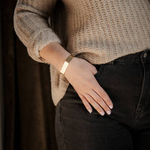 Load image into Gallery viewer, Person wearing a beige sweater and dark jeans with a gold bracelet on a neutral background