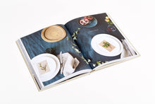 Load image into Gallery viewer, Open book showing images of table settings and food on a white background
