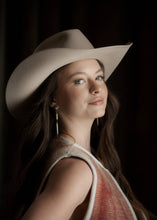 Load image into Gallery viewer, Woman wearing a beige cowboy hat against a dark background