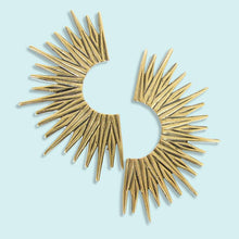 Load image into Gallery viewer, Gold sunburst earrings on a light blue background