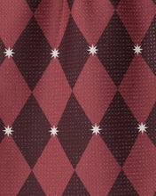 Load image into Gallery viewer, A close-up of a textured fabric with an argyle pattern in dark red and deep brown, accented with small white starburst motifs at the intersections.