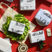 Load image into Gallery viewer, Assorted soap bars with decorative packaging on a red surface