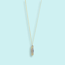 Load image into Gallery viewer, Gold necklace with a unique pendant on a light blue background