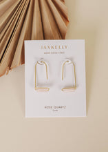 Load image into Gallery viewer, Gold earrings on a Jaxkelly branded card with a beige background