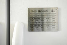 Load image into Gallery viewer, Metal measuring equivalence chart on a white surface