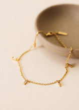 Load image into Gallery viewer, Gold anklet on a beige surface with a neutral background