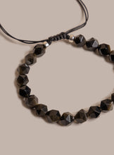 Load image into Gallery viewer, Necklace with black faceted beads on a beige background