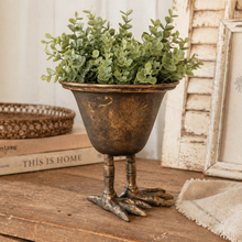 Load image into Gallery viewer, Decorative metal planter with green plant on a wooden surface with books and a framed picture in the background.