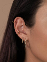 Load image into Gallery viewer, Close-up of an ear with gold earrings against a neutral background
