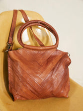 Load image into Gallery viewer, Brown leather handbag with a chevron pattern on a beige surface