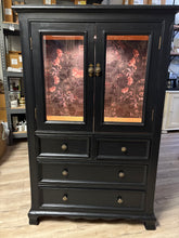 Load image into Gallery viewer, Black cabinet with glass shelf and and drawers on a wooden floor