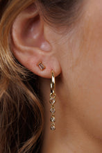 Load image into Gallery viewer, Close-up of a gold hoop earring with dangling beads worn by a person.