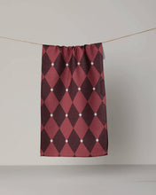 Load image into Gallery viewer, A towel panel with a burgundy and dark red harlequin diamond pattern, decorated with small white starburst accents, hanging from a thin string against a neutral light gray wall.