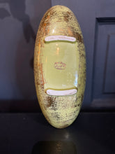 Load image into Gallery viewer, Decorative item with a label on a dark background