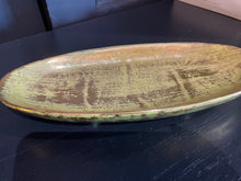 Load image into Gallery viewer, Oval ceramic plate with a textured surface on a dark background