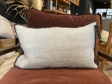 Load image into Gallery viewer, Decorative pillow with a visible tag on a brown chair