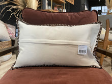 Load image into Gallery viewer, White pillow with brown trim on a brown chair in a store setting