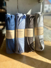 Load image into Gallery viewer, Four scaaves rin blue, gray, and white with 'rubyzaar' labels on a wooden surface.