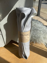 Load image into Gallery viewer, Gray scarf with a brand label on a wooden surface