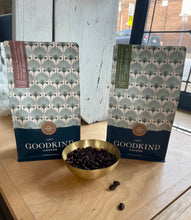 Load image into Gallery viewer, Two Goodkind Coffee packages with a bowl of coffee beans on a wooden surface.