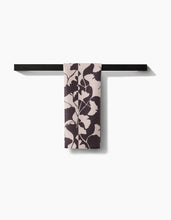 Load image into Gallery viewer, Floral-patterned towel hanging on a black towel rack against a white background
