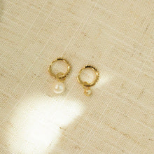 Load image into Gallery viewer, Two small hoop earrings on a textured background