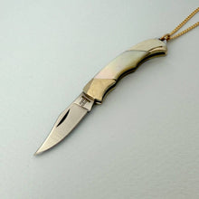 Load image into Gallery viewer, Gold and silver knife pendant on a light gray background