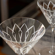 Load image into Gallery viewer, Close-up of a clear glass with geometric etching on a reflective surface.