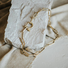 Load image into Gallery viewer, Gold chain necklace on a textured stone surface