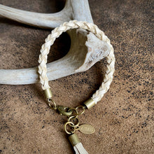 Load image into Gallery viewer, Bracelet with braided design and gold accents on a textured surface