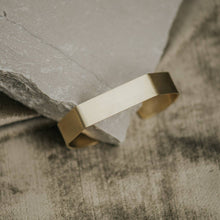 Load image into Gallery viewer, Gold bracelet on a textured stone surface