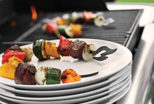 Load image into Gallery viewer, Stack of white plates with black designs, featuring skewers of vegetables and meat on a grill in the background.