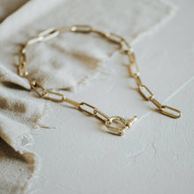 Load image into Gallery viewer, Gold chain necklace on a textured surface