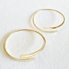 Load image into Gallery viewer, Gold hoop bracelet on a textured white background