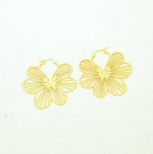 Load image into Gallery viewer, Gold flower-shaped hoop earrings on a light beige background