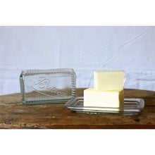 Load image into Gallery viewer, Two blocks of butter on a glass 'To Butter' dish with a white background