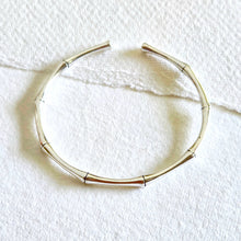 Load image into Gallery viewer, Silver bracelet on a white textured surface