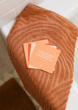 Load image into Gallery viewer, Brown towel draped over a surface with cards on top