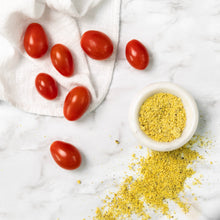 Load image into Gallery viewer, Tomatoes and a bowl of yellow spice on a marble surface