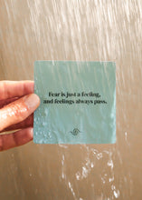 Load image into Gallery viewer, Hand holding a card with a motivational quote against a water background