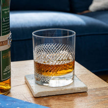 Load image into Gallery viewer, Glass of whiskey on a coaster next to a bottle on a wooden surface with a blurred background