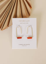 Load image into Gallery viewer, A pair of carnelian agate drop earrings with gold plating, displayed on a white card with the brand name 'JAXKELLY' written at the top.