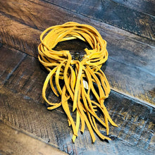 Load image into Gallery viewer, A yellow deerskin leather cuff bracelet with an antique-brass, magnetic sliding clasp, displayed on a wooden surface.