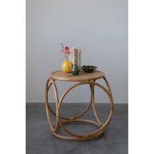 Load image into Gallery viewer, Curved rattan side table with decor items on a grey surface.