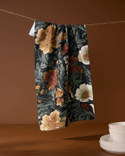 Load image into Gallery viewer, Floral-patterned towel hanging on a line with a brown background

